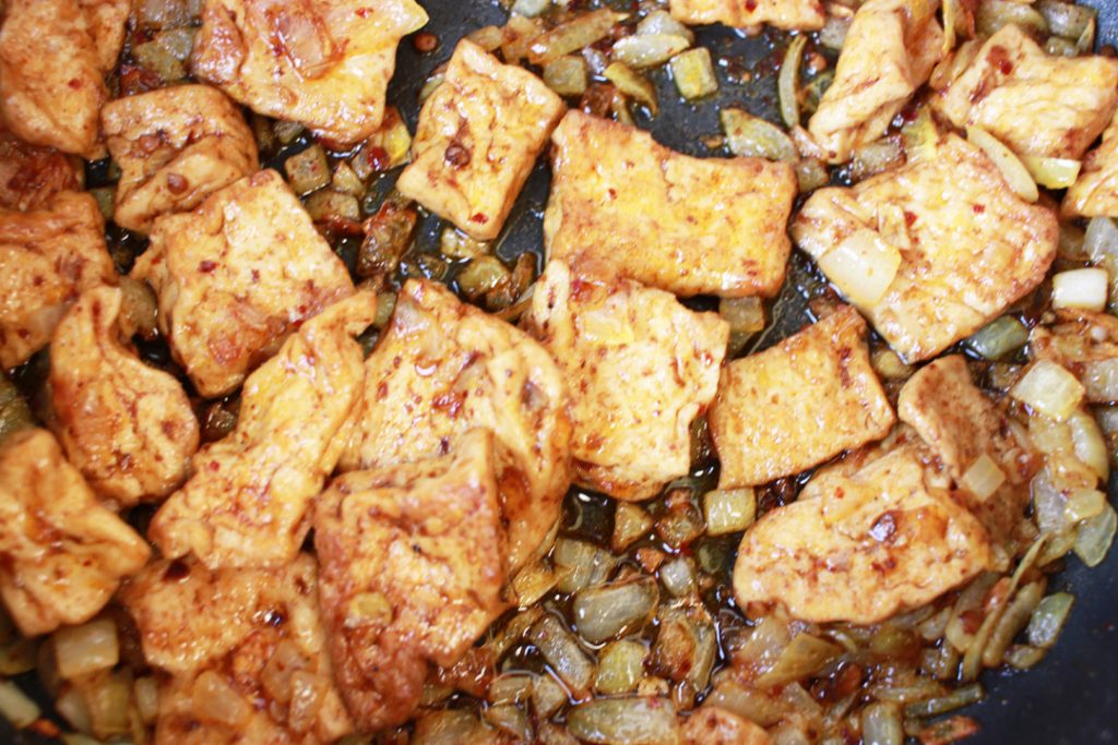 Für die vegane Hühnerbrühe den Szechuan Tofu mit den Zwiebeln anbraten